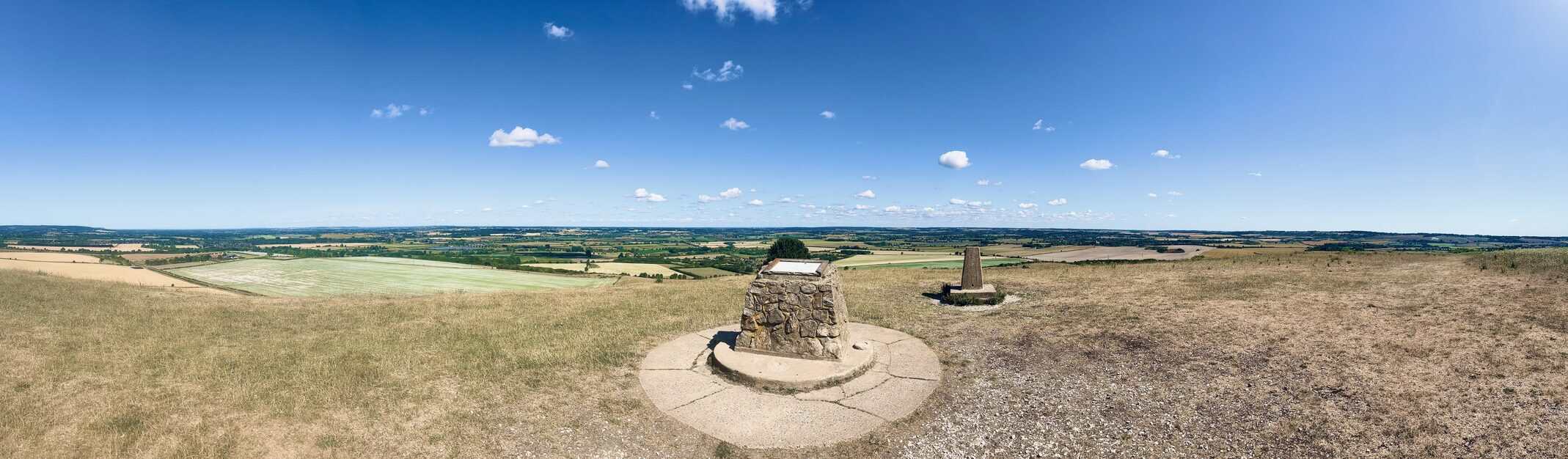 Udsigt fra Ivinghoe Beacon i Storbritannien med stenvarde og åbent landskab.