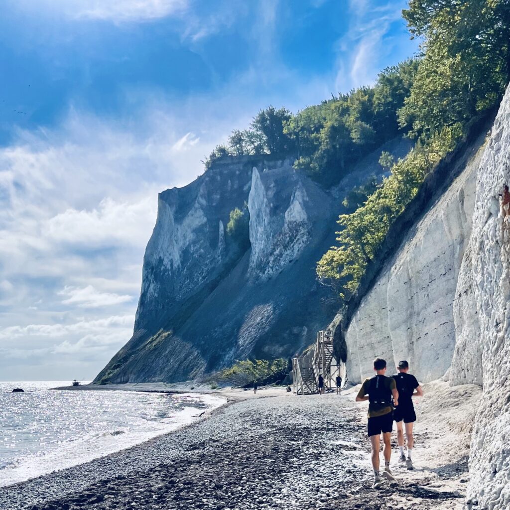 To løbere på stranden under de hvide klinter ved Møns Klint under South Coast Ultra 50K.