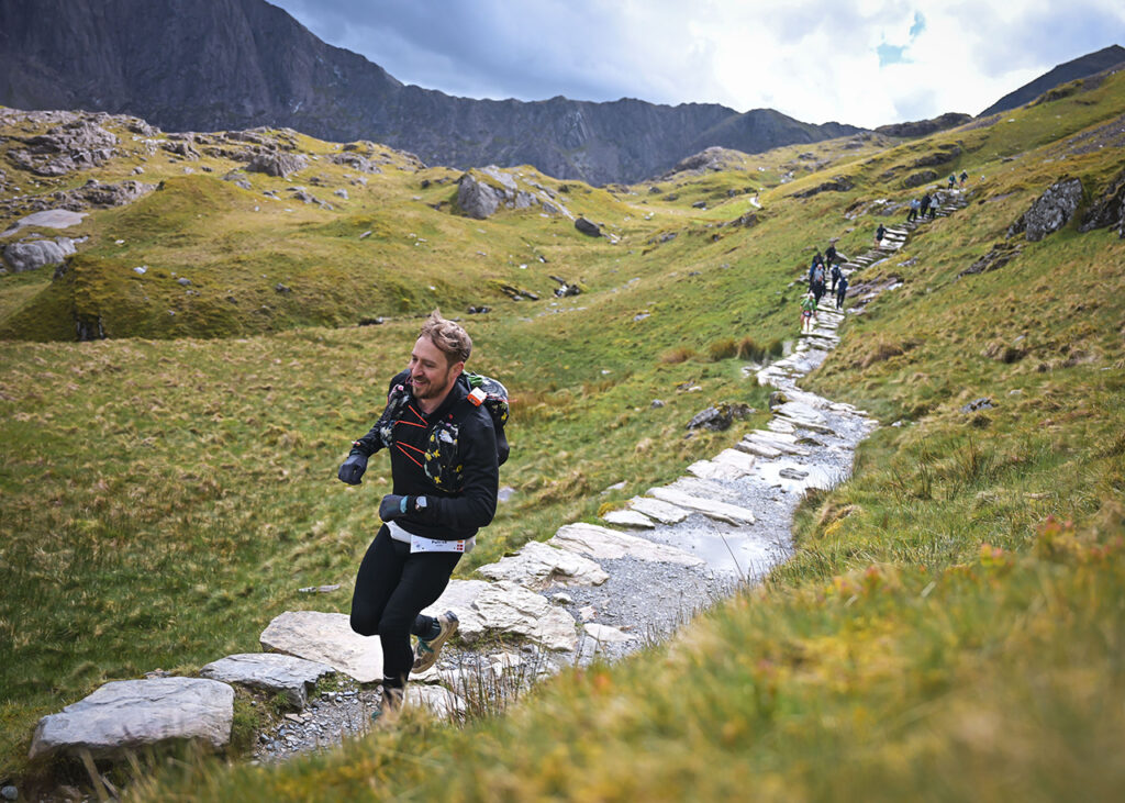 Patrick Bloem løber op ad en stenet bjergsti under Ultra Trail Snowdonia.