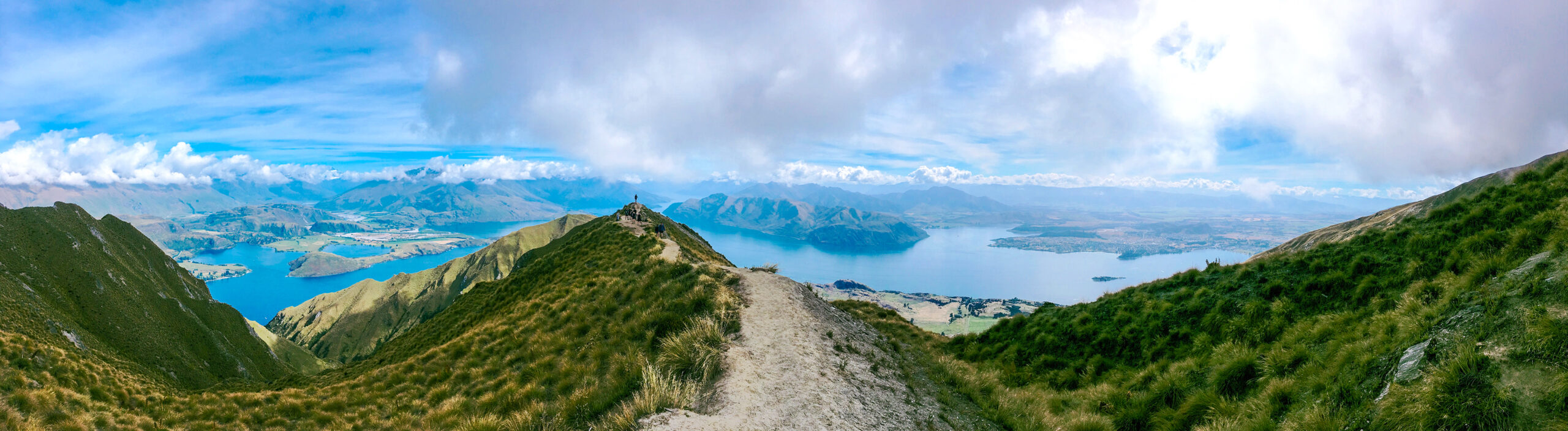 Mountain trail on Roys Peak near Wānaka, overlooking Lake Wānaka and the surrounding mountains in New Zealand.