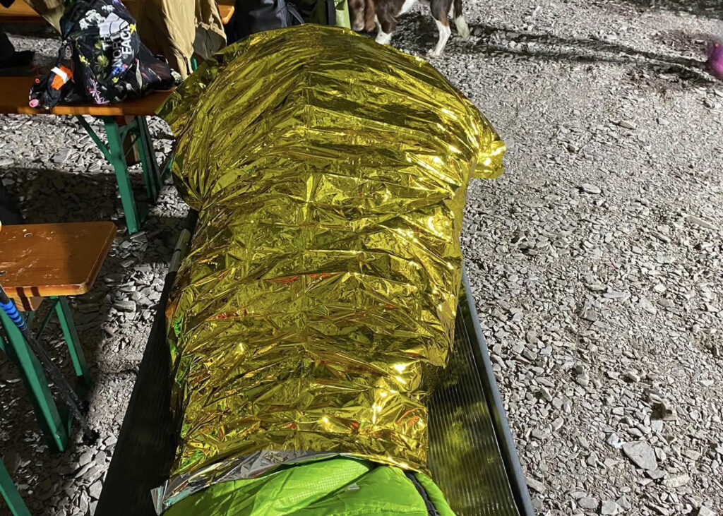Løber pakket ind i redningstæppe på en bænk ved en hjælpestation under Ultra Trail Snowdonia.